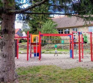 a child walking in a playground next to a tree at Haus Löwenzahn in Hüttenrode