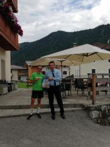 two men standing next to each other under an umbrella at Hotel Serenella in Canale San Bovo