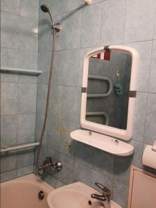 y baño con ducha, lavabo y espejo. en Квартира возле парка Б. Хмельницкого (центр) из первых рук, en Cherníhiv