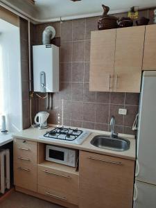 a small kitchen with a sink and a stove at Квартира возле парка Б. Хмельницкого (центр) из первых рук in Chernihiv
