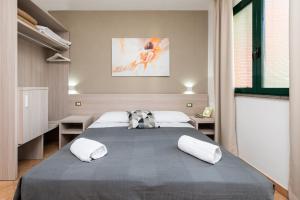 een slaapkamer met een groot bed met 2 kussens bij Casa Betania in Pisa