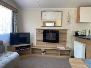 a living room with a flat screen tv in a room at KellysHolidayHomes Atlas 3 bedrooms caravan in Weeley