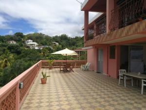- un balcon d'une maison avec une table et un parasol dans l'établissement Villa la colliniere, à La Trinité