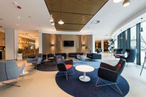 a waiting area in a hospital with chairs and tables at Holiday Inn Express Warsaw - Mokotow, an IHG Hotel in Warsaw