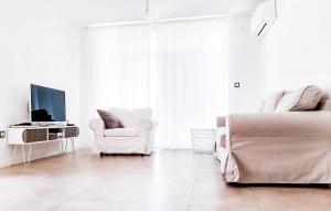 Sala de estar blanca con sofá y silla en Villa Regina Serafina, en Balchik