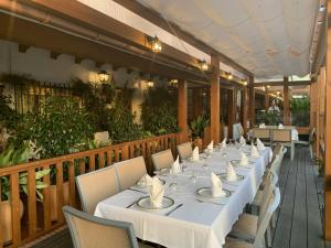 una mesa larga con mesas blancas y sillas en un restaurante en Hotel Antonio Conil, en Conil de la Frontera