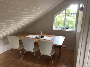 a table and chairs in a room with a window at Ramsbu utsikt terasse selvhushold in Hovden