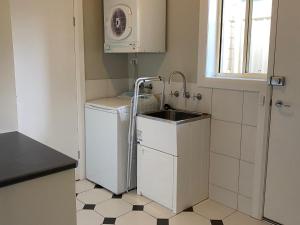 a small kitchen with a sink and a washing machine at Apartment 244 on Bertha, Mount Gambier in Mount Gambier