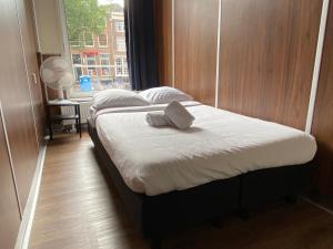 1 dormitorio con 2 camas con almohadas blancas y ventana en Hostel Utopia, en Ámsterdam