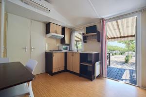 a room with a kitchen with a table and a window at Alannia Costa Dorada in Platja de l’Almadrava