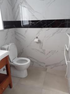 a white bathroom with a toilet and a sink at J&D Cottage in Kerikeri