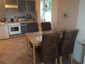 a kitchen with a wooden dining table and chairs at Ferienhaushälfte Domeyer Midlum in Midlum