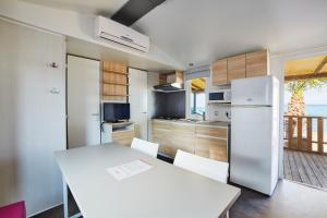 a kitchen with a white table and a refrigerator at Alannia Costa Dorada in Platja de l’Almadrava