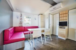 a living room with a red couch and a table at Alannia Costa Dorada in Platja de l’Almadrava