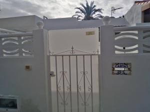 a white gate in front of a white fence at House Lilu - luminoso monolocale in Arona