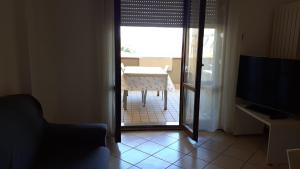 ein Wohnzimmer mit einem Tisch und Blick auf ein Zimmer in der Unterkunft A due passi dal mare in Porto Recanati