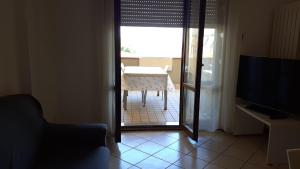 a living room with a table and a view of a room at A due passi dal mare in Porto Recanati