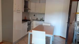 uma cozinha com armários brancos e uma mesa e cadeiras em A due passi dal mare em Porto Recanati