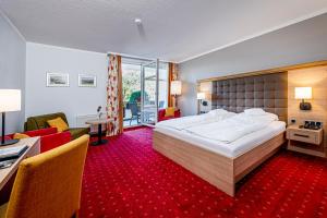 Habitación de hotel con cama grande y sala de estar. en Landhotel Buller en Hagen