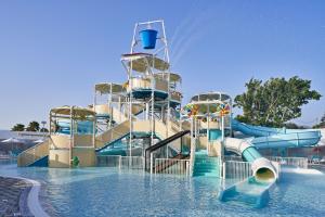 a water park with a water slide in the water at Atlantica Mare Village Paphos in Paphos