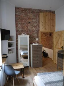 1 dormitorio con espejo, tocador y pared de ladrillo en Kamienica Bydgoska 3, en Bydgoszcz