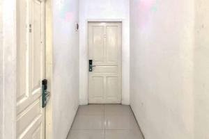 een lege hal met een witte deur en een tegelvloer bij Ancol Homestay in Jakarta