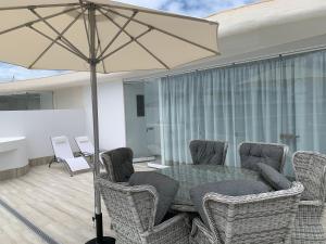 a patio with a table and chairs and an umbrella at Penthouse Las Olas in Palm-Mar