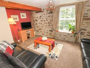 a living room with a leather couch and a table at The Old Mill in Milford Haven