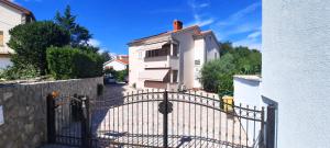 un cancello di fronte a una casa bianca di Apartment Jan a Krk
