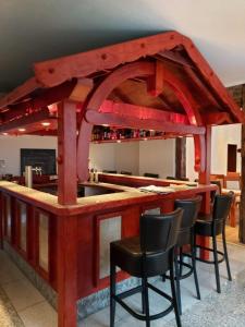 a bar with black chairs and a red counter at Landhaus Wildemann in Wildemann