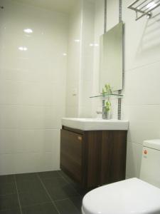 y baño con lavabo, aseo y espejo. en Penghu 123 V-Stone, en Magong
