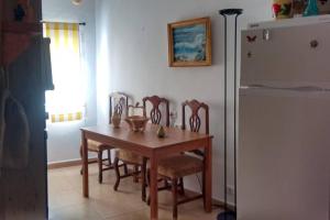 d'une salle à manger avec une table, des chaises et un réfrigérateur. dans l'établissement Alojamiento Rural Jacinta, à Torres de Albanchez