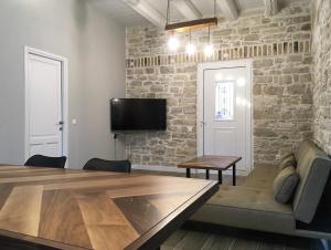 une salle à manger avec une table et un mur en briques dans l'établissement Villa Antonis, à Lakka