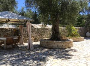 una mesa y un árbol con sombrilla en Villa Antonis, en Lákka