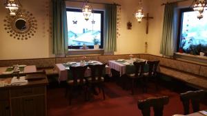 a dining room with tables and chairs and a window at Pension Haus Inge in Zwiesel