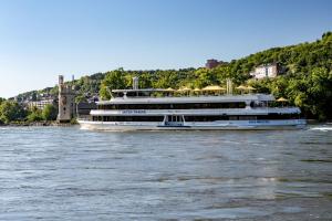 un grand bateau sur l'eau sur une rivière dans l'établissement Rheinhotel Starkenburger Hof, à Bingen am Rhein