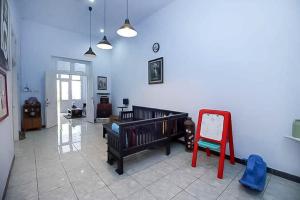 a room with a crib and a chair in it at RedDoorz Near Stasiun Lawang in Lawang