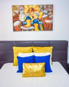 a bed with blue and yellow pillows and a painting at House near CR7 Museum in Funchal