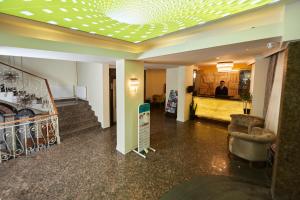 イスタンブールにあるSunlight Hotel & SPAの緑の天井のロビーと鏡の男性