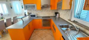 una cucina con mobili arancioni e un lavandino di Apartment Jan a Krk