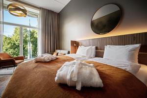 a bedroom with a large bed with a large mirror on the wall at Karl Johan Hotel in Oslo