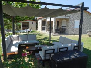 un patio con sofás blancos y una mesa en Costa Petra - Luxury Seaside Cottage with Garden - Vacation House for families in Greece, en Néa Meságkala