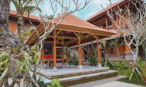dom z pomarańczowym dachem i werandą w obiekcie Ubud Hotel & Cottages w mieście Malang