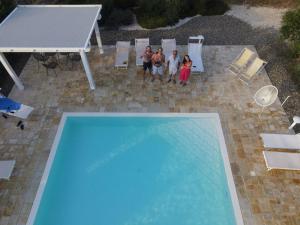 eine Gruppe von Personen, die neben einem Schwimmbad stehen in der Unterkunft L'Uliveto in Cisternino