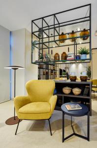 a living room with a yellow chair and a table at Sercotel Madrid Aeropuerto in Madrid