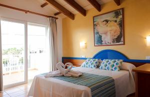 a bedroom with a bed with a towel on it at Sagitario Villas in Son Carrio