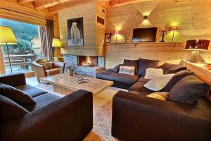 un salon avec un canapé et une cheminée dans l'établissement Chalet Prestige serrechevalierholidays 20 personnes, au Monêtier-les-Bains