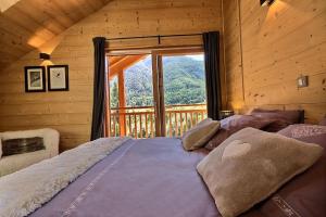 une chambre avec un grand lit avec une grande fenêtre dans l'établissement Chalet Prestige serrechevalierholidays 20 personnes, au Monêtier-les-Bains