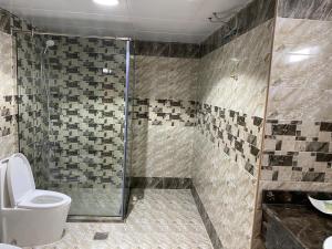 a bathroom with a shower and a toilet at Al Massa Hotel in Al Ain