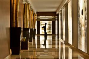 a person walking down a hallway with a door open at Palácio Estoril Hotel, Golf & Wellness in Estoril